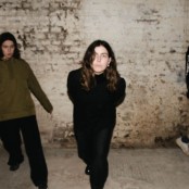 Trio Voka Gentle stood in front of a brick wall